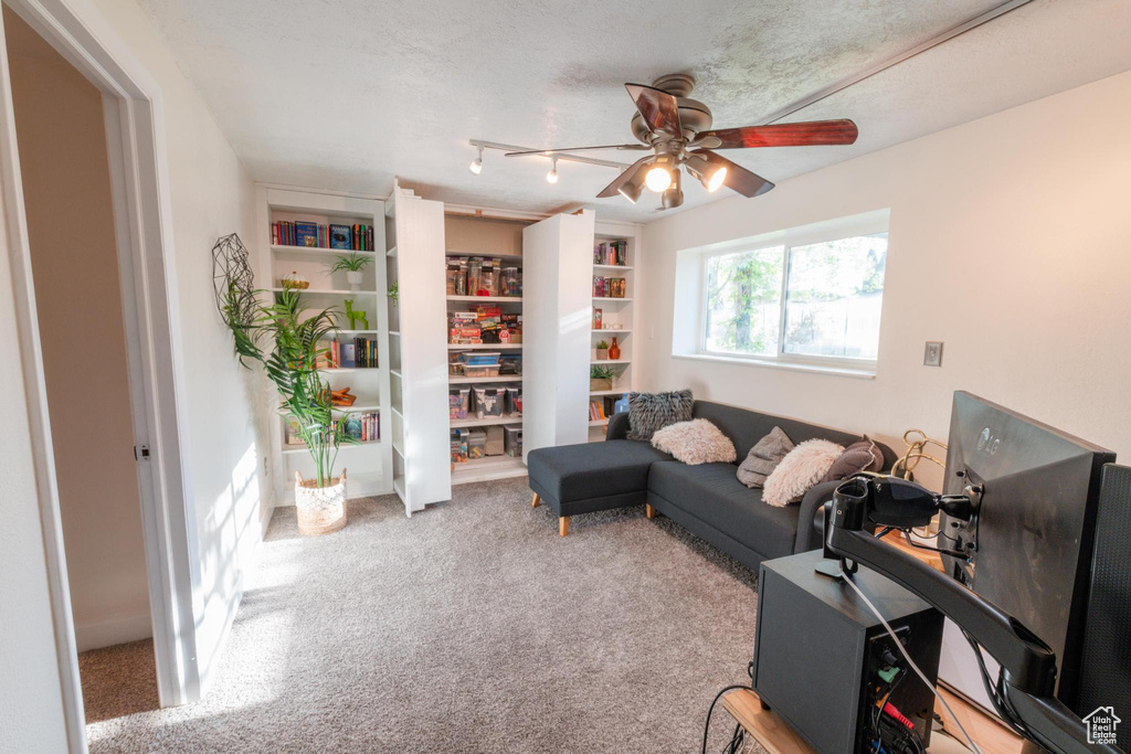 Living room with carpet flooring and a ceiling fan