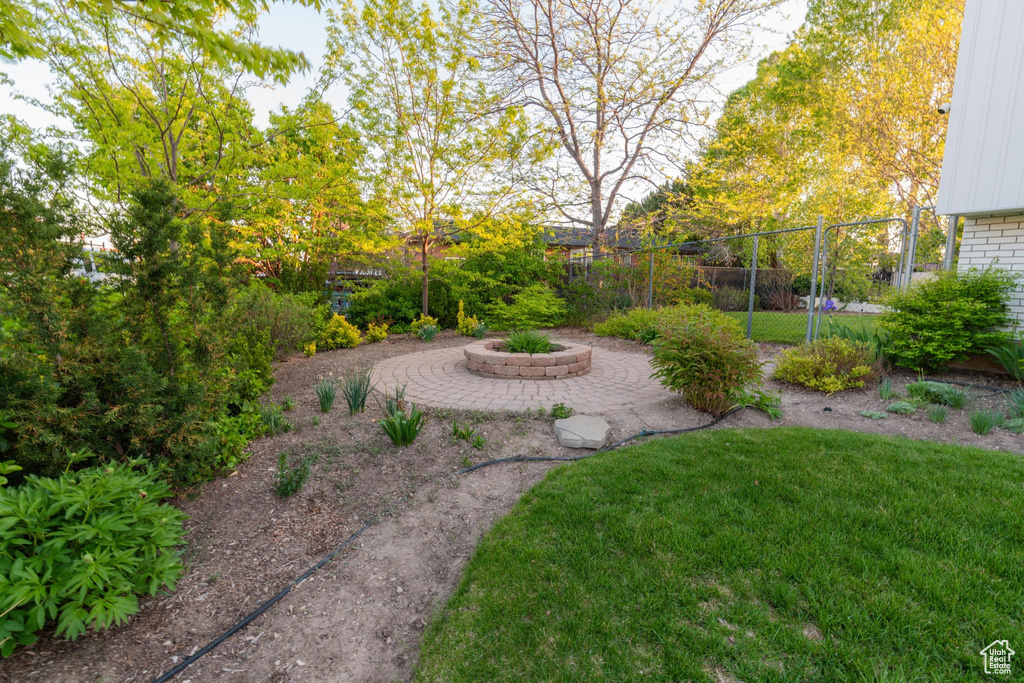 View of yard featuring a fire pit and fence