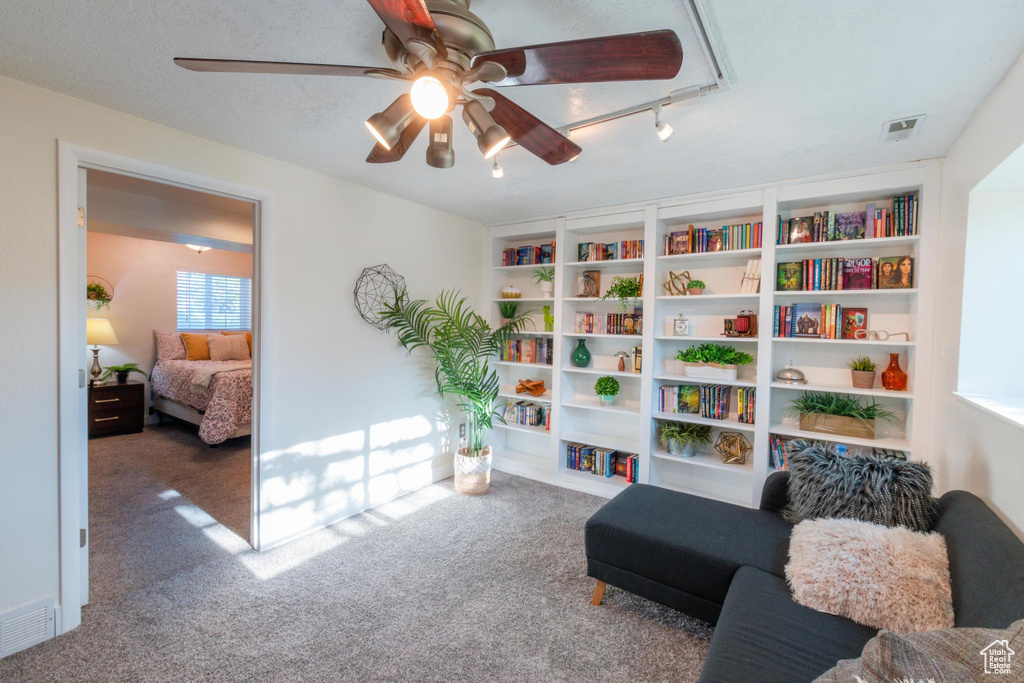 Sitting room with carpet floors, ceiling fan, and visible vents