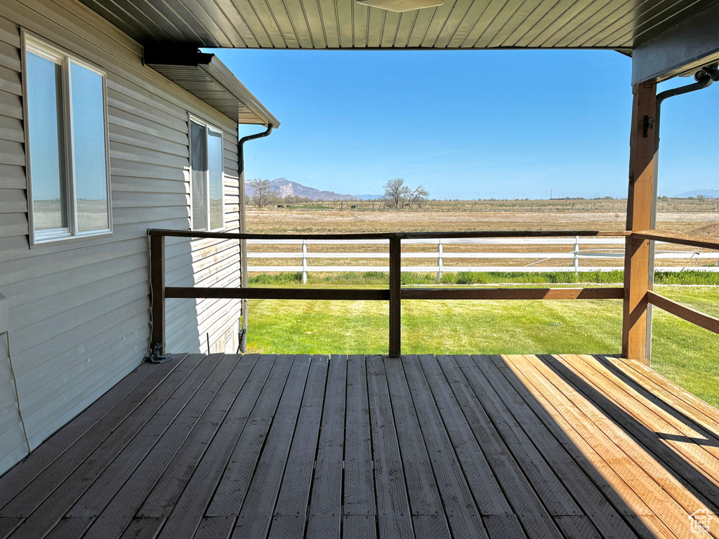 Wooden deck with a mountain view, a yard, a rural view, and fence