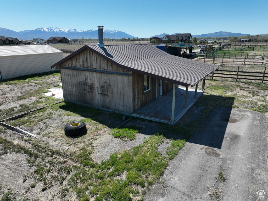 View of side of property with fence, metal roof, and a mountain view