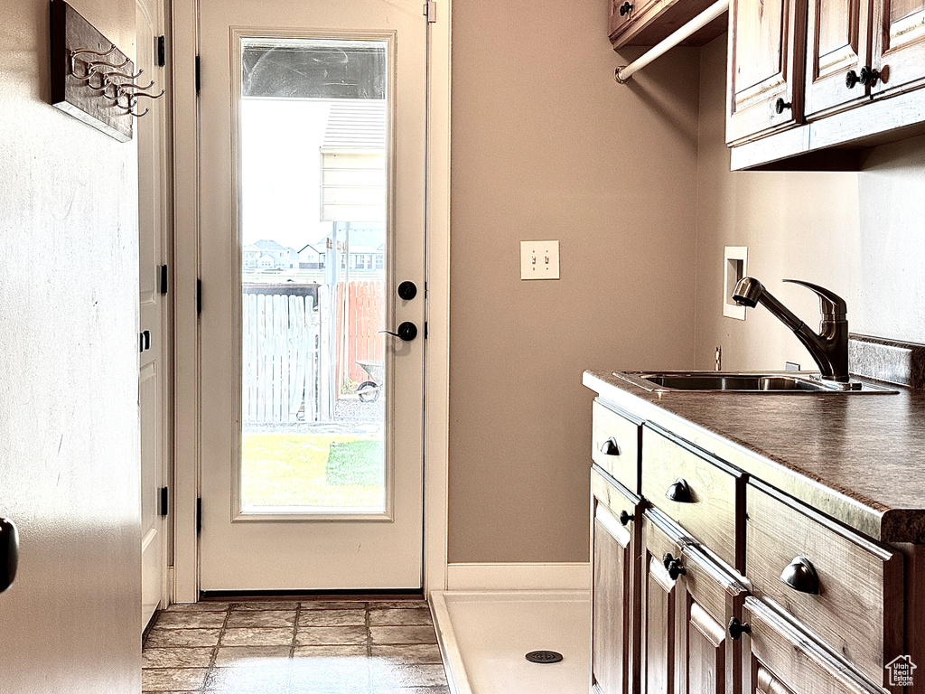 Laundry area with a sink, hookup for a washing machine, cabinet space, and a wealth of natural light