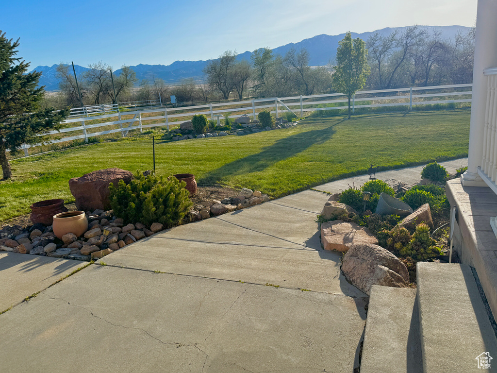 View of yard with a rural view, a mountain view, and a fenced backyard