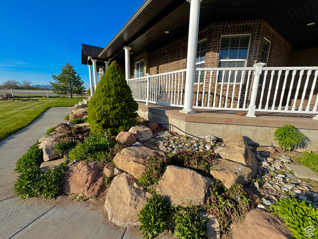View of side of property with covered porch and brick siding