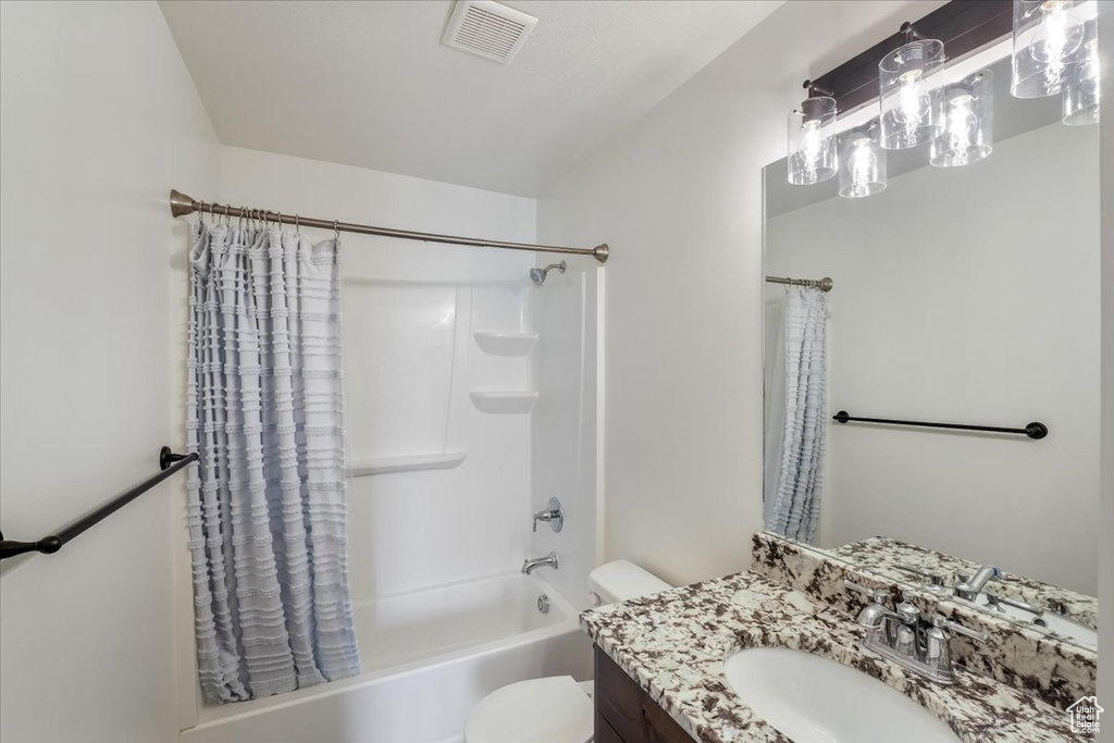 Full bath featuring visible vents, shower / tub combo with curtain, toilet, and vanity