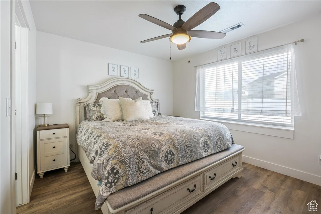 Bedroom with a ceiling fan, baseboards, visible vents, and dark wood finished floors