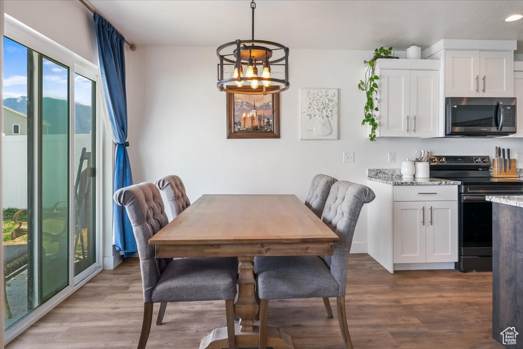 Dining area with recessed lighting, a chandelier, and wood finished floors