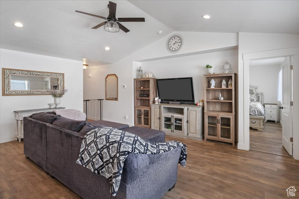 Living room with wood finished floors, recessed lighting, ceiling fan, and lofted ceiling
