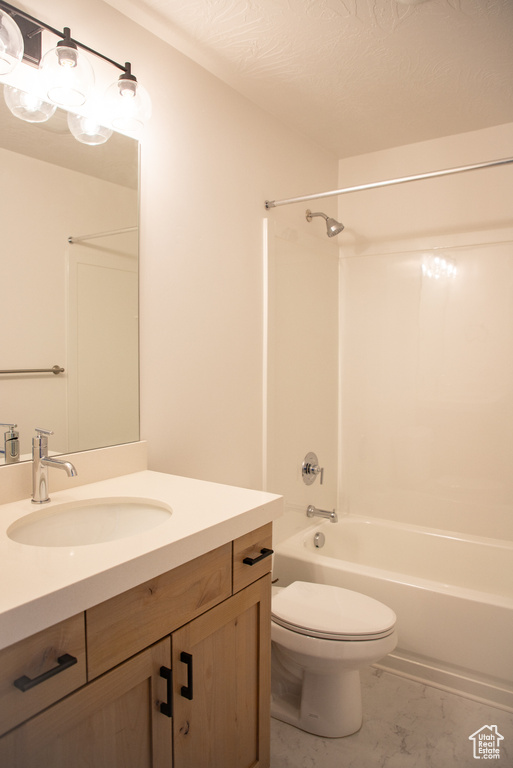 Full bath with vanity,  shower combination, and marble look tile flooring