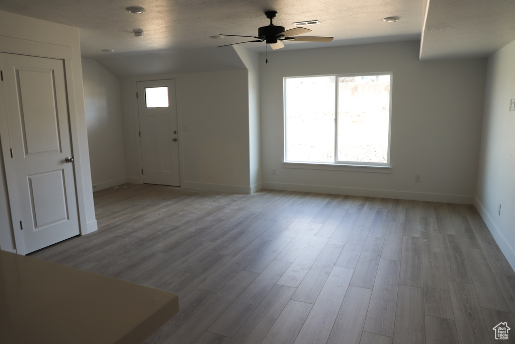 Foyer featuring baseboards, a ceiling fan, wood finished floors, and visible vents