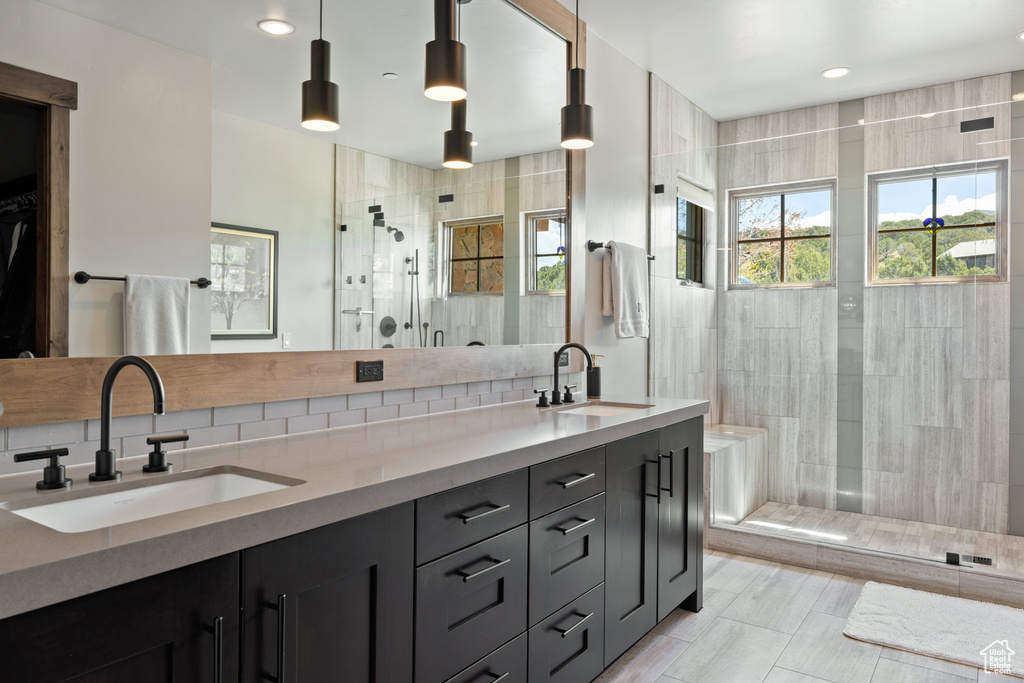 Full bath with a sink, a walk in shower, and backsplash