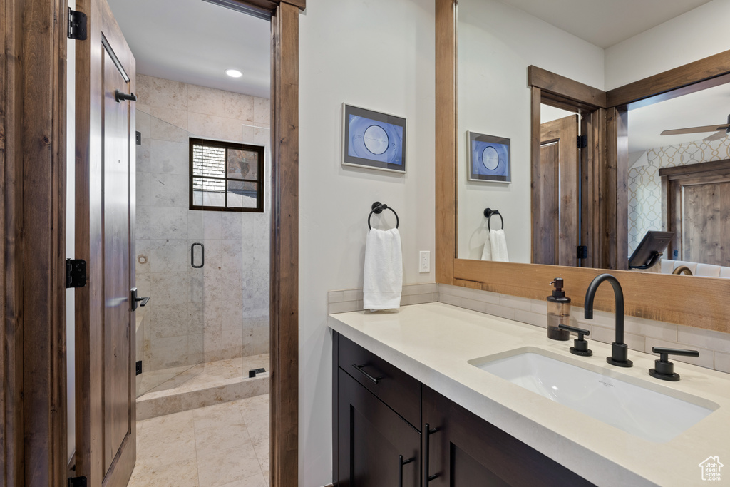 Full bath featuring vanity, ceiling fan, tile patterned flooring, and a stall shower