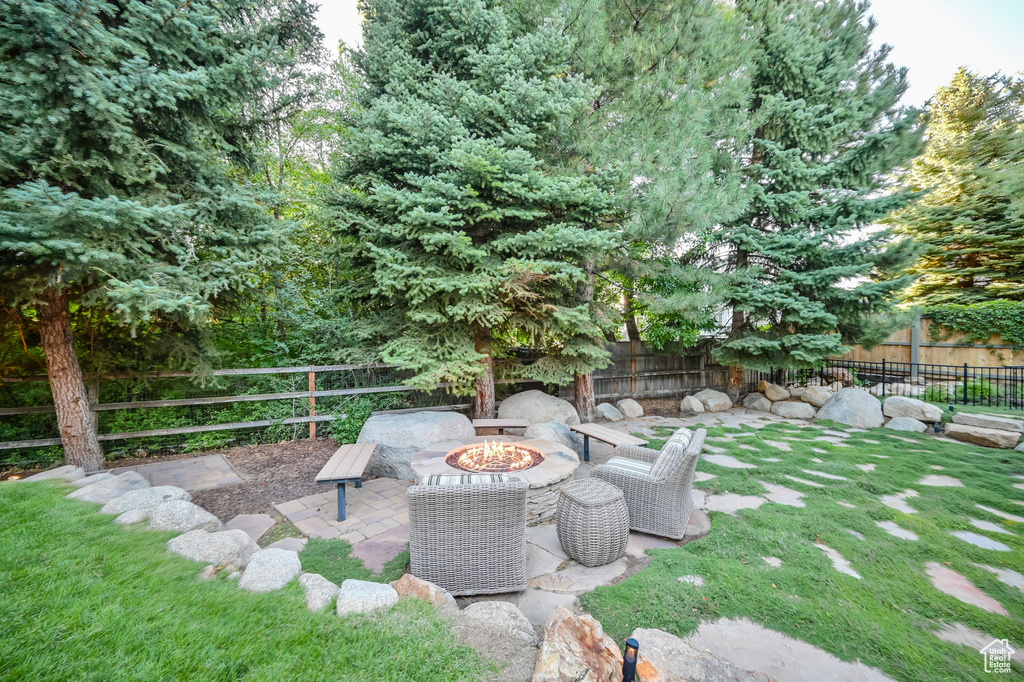 View of yard featuring a patio, a fenced backyard, and a fire pit