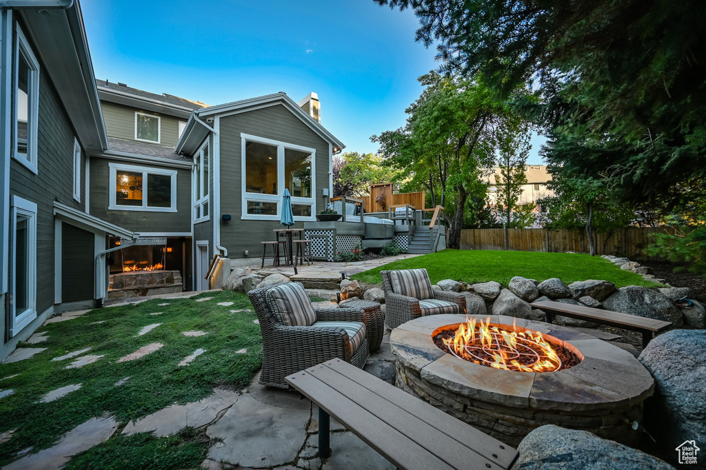 Exterior space featuring a deck, fence, and a fire pit