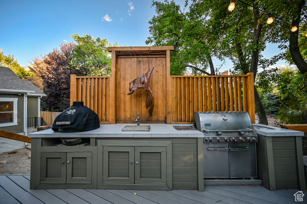 View of patio / terrace with exterior kitchen, a deck, and a grill