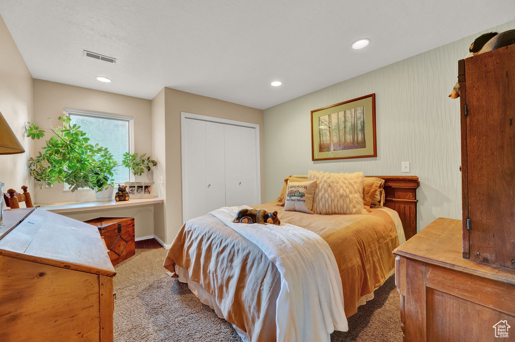Carpeted bedroom featuring recessed lighting, baseboards, visible vents, and a closet