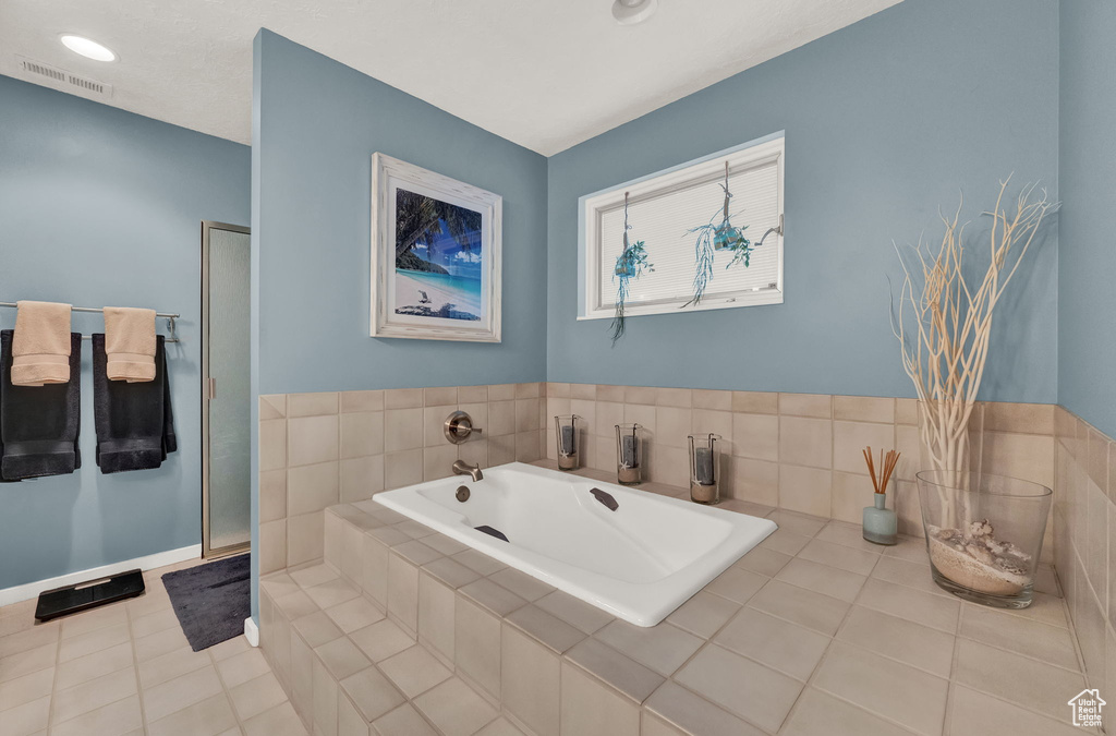 Full bathroom with tile patterned floors, a shower with door, a bath, and visible vents