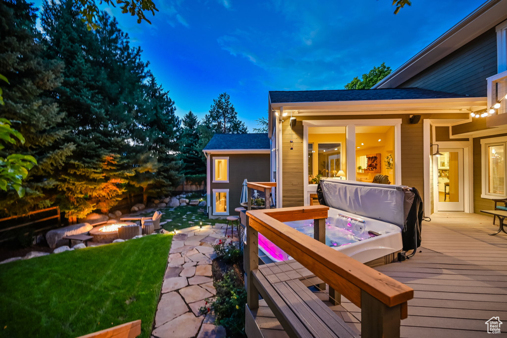 Wooden deck with a lawn and an outdoor fire pit