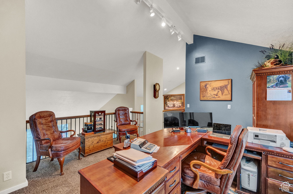 Office with track lighting, vaulted ceiling with beams, carpet floors, and visible vents
