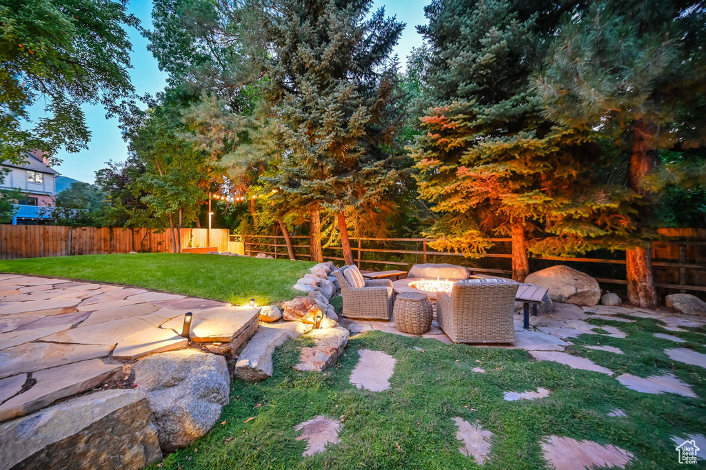 View of yard featuring a patio, a fenced backyard, and an outdoor living space with a fire pit