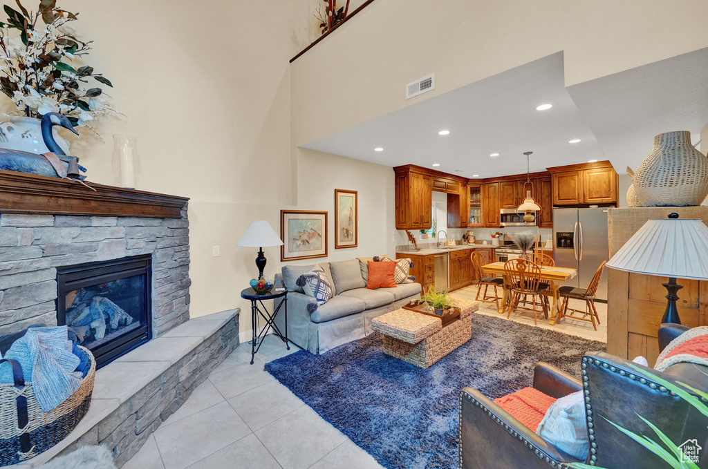Living room featuring visible vents, a fireplace, light tile patterned floors, baseboards, and recessed lighting
