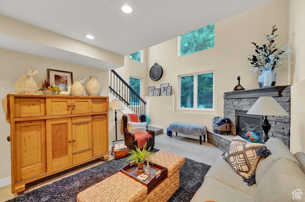 Living room with recessed lighting, stairs, light tile patterned floors, and a fireplace