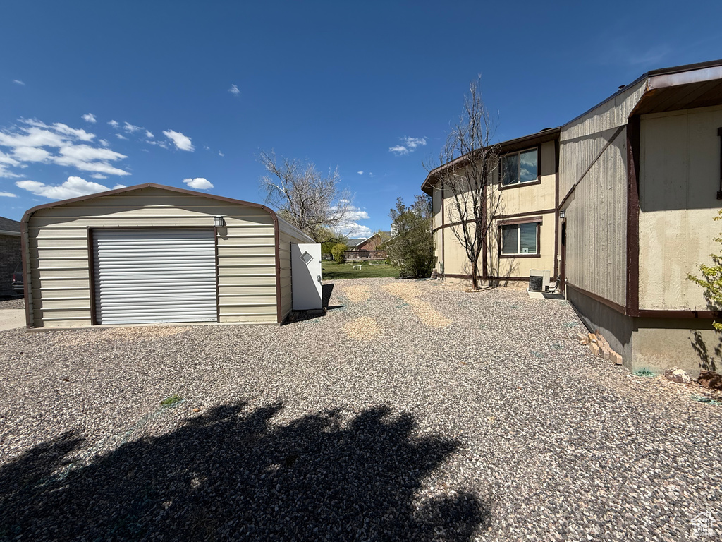 Exterior space featuring an outdoor structure, central AC unit, and a detached garage