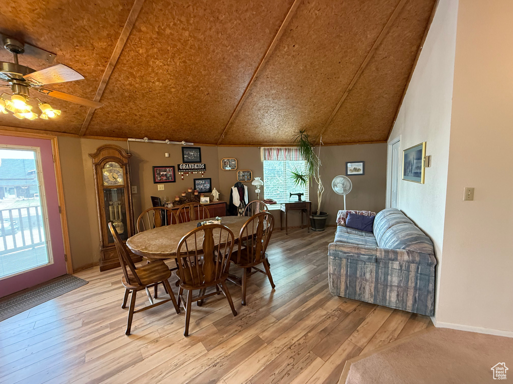 Dining area featuring ceiling fan, lofted ceiling, and light wood-style floors