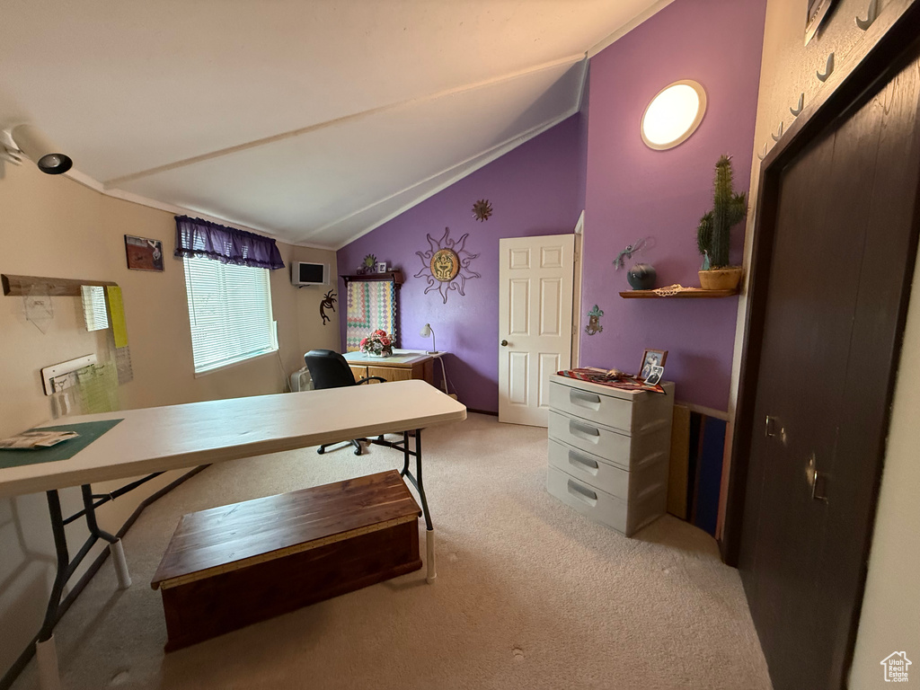 Home office with light carpet and vaulted ceiling
