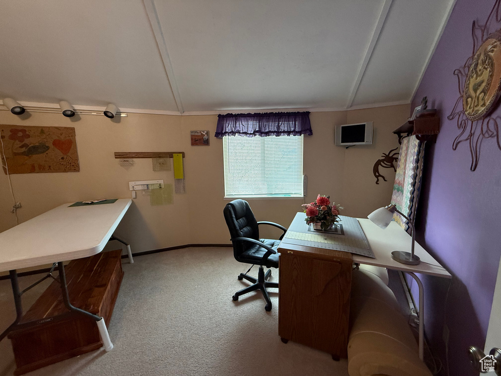 Carpeted home office featuring baseboards, ornamental molding, and vaulted ceiling