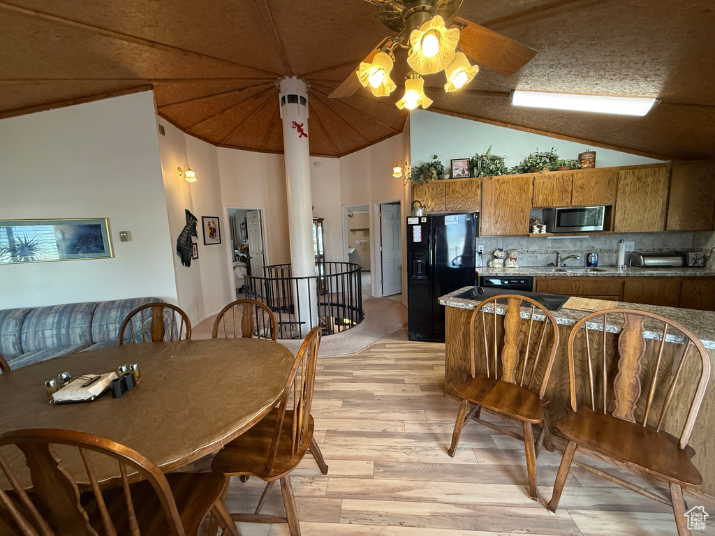 Dining area featuring a toaster, a ceiling fan, light wood-style flooring, and lofted ceiling