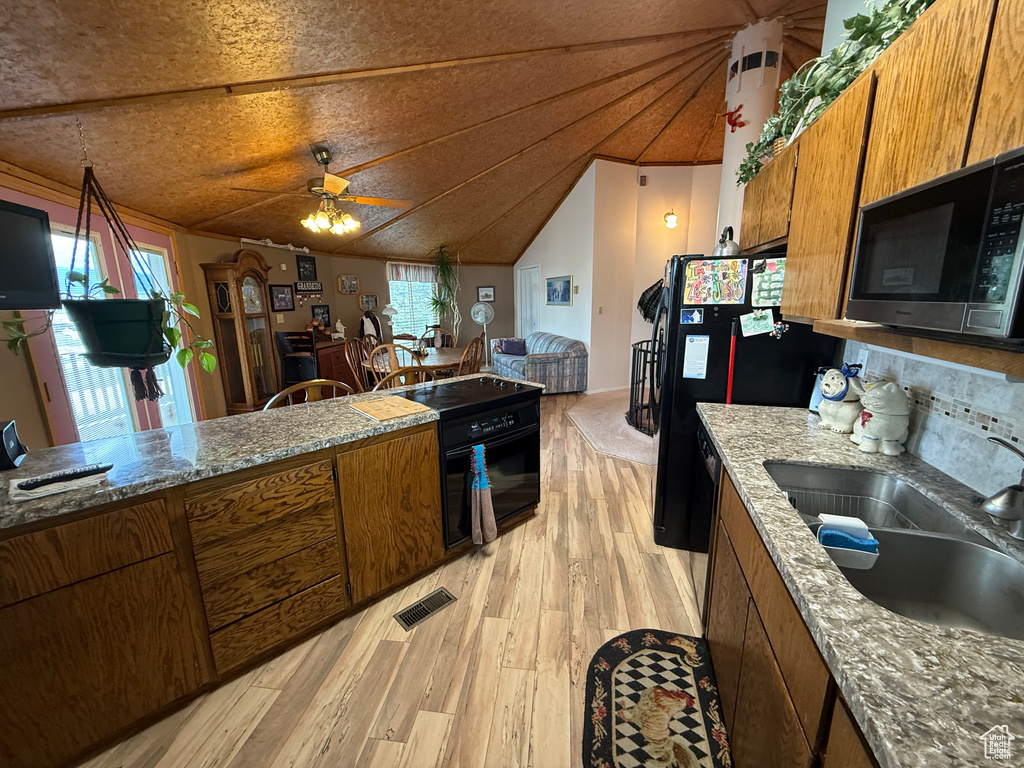 Kitchen with brown cabinets, ceiling fan, a sink, light wood-style floors, and black appliances