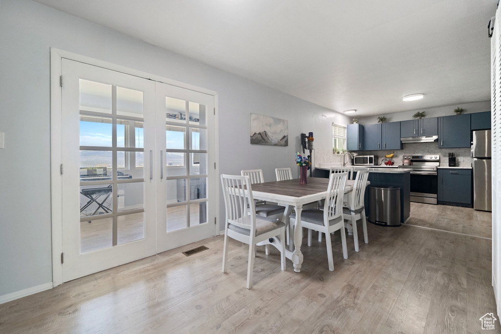 Dining area featuring visible vents, light wood-style floors, and a healthy amount of sunlight