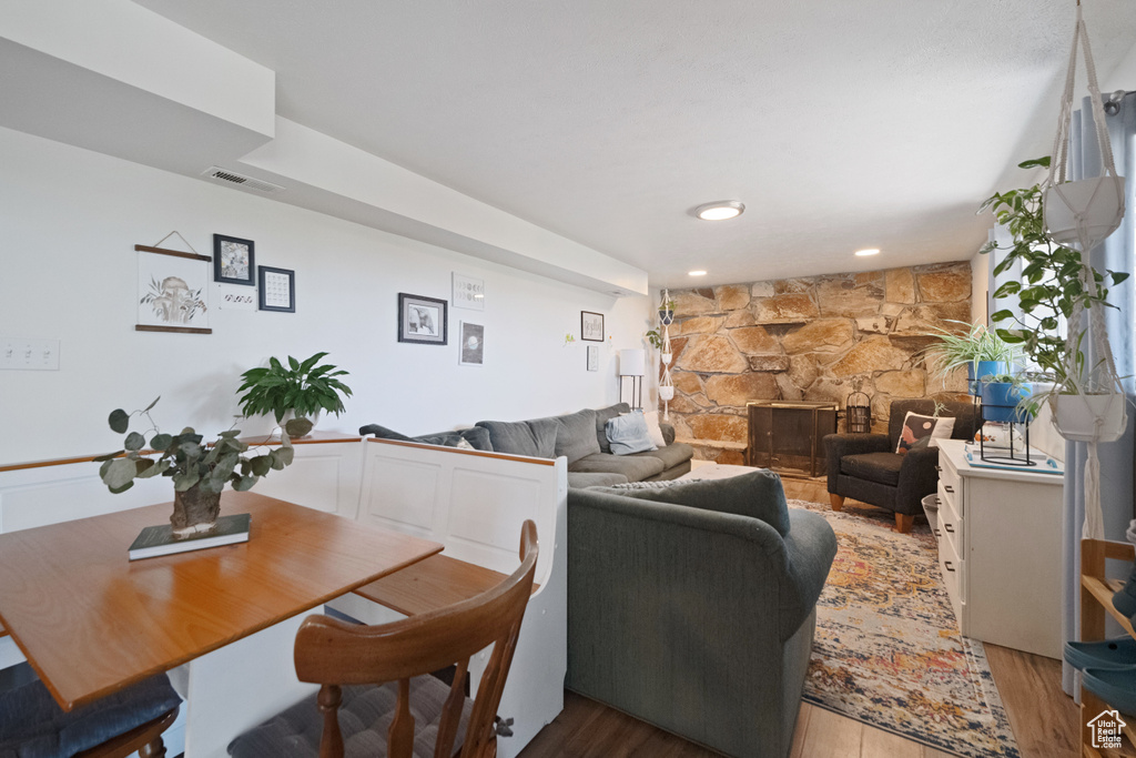 Living room with visible vents, light wood-style flooring, and a fireplace
