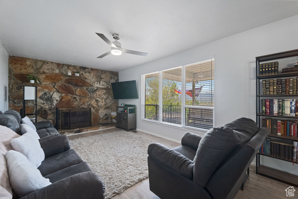 Living area featuring ceiling fan, baseboards, and wood finished floors