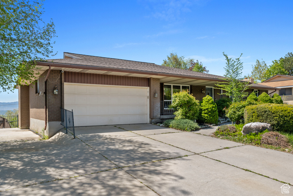 Ranch-style home with an attached garage, brick siding, and concrete driveway