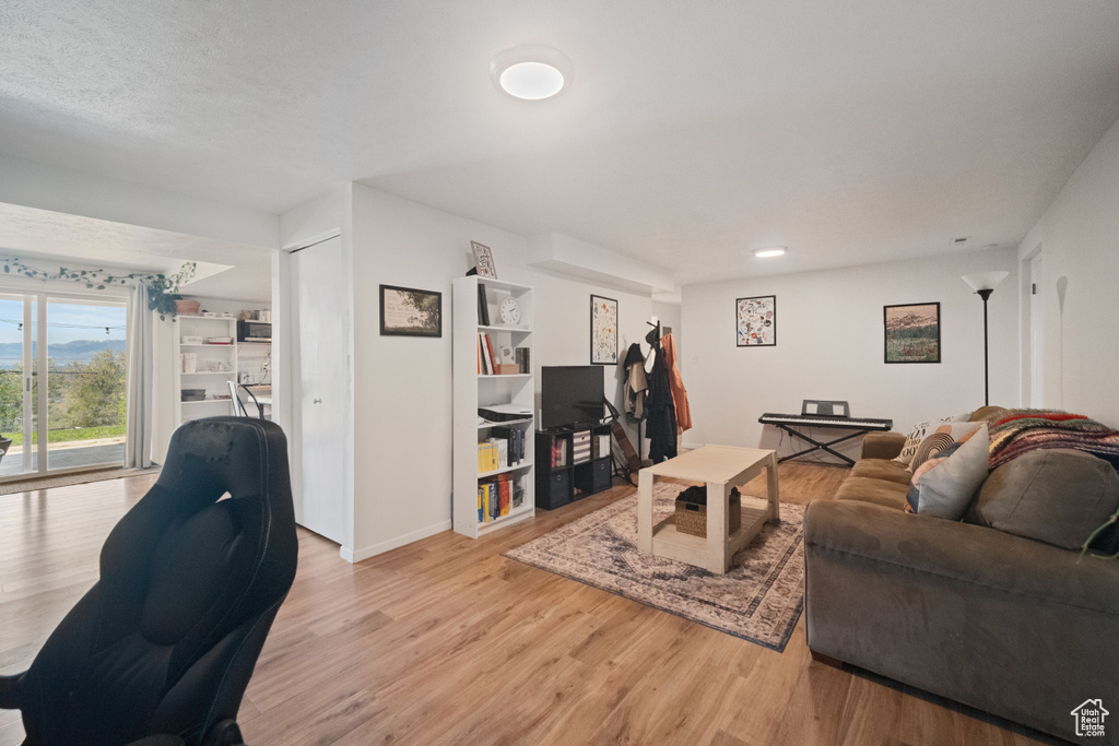 Living room with baseboards, recessed lighting, and light wood-style flooring