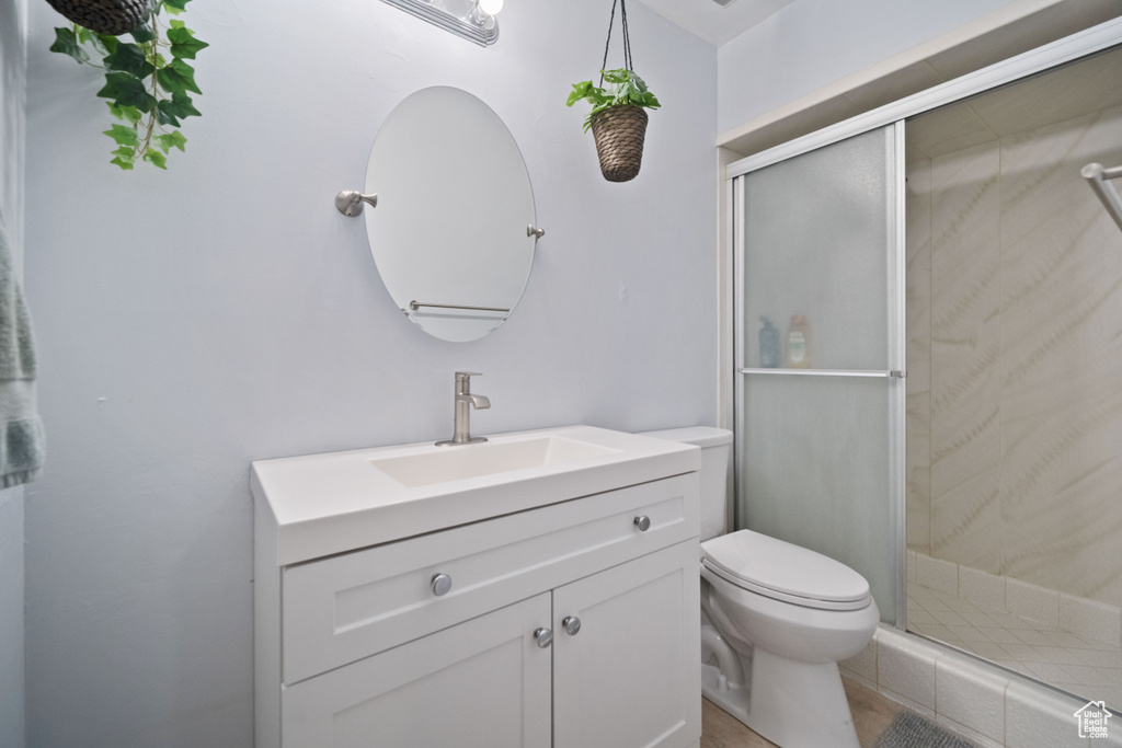 Full bathroom featuring vanity, a shower stall, and toilet