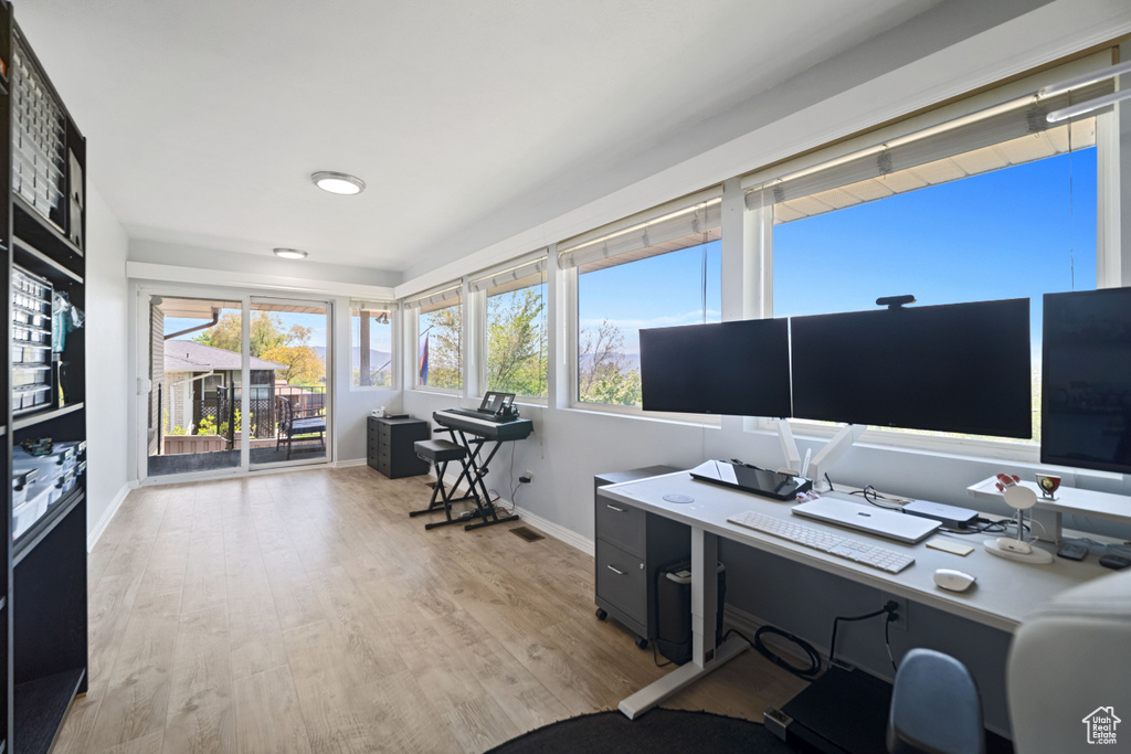 Office area with baseboards, visible vents, and light wood-type flooring