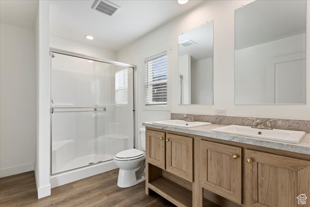 Bathroom with visible vents, a sink, a stall shower, and toilet