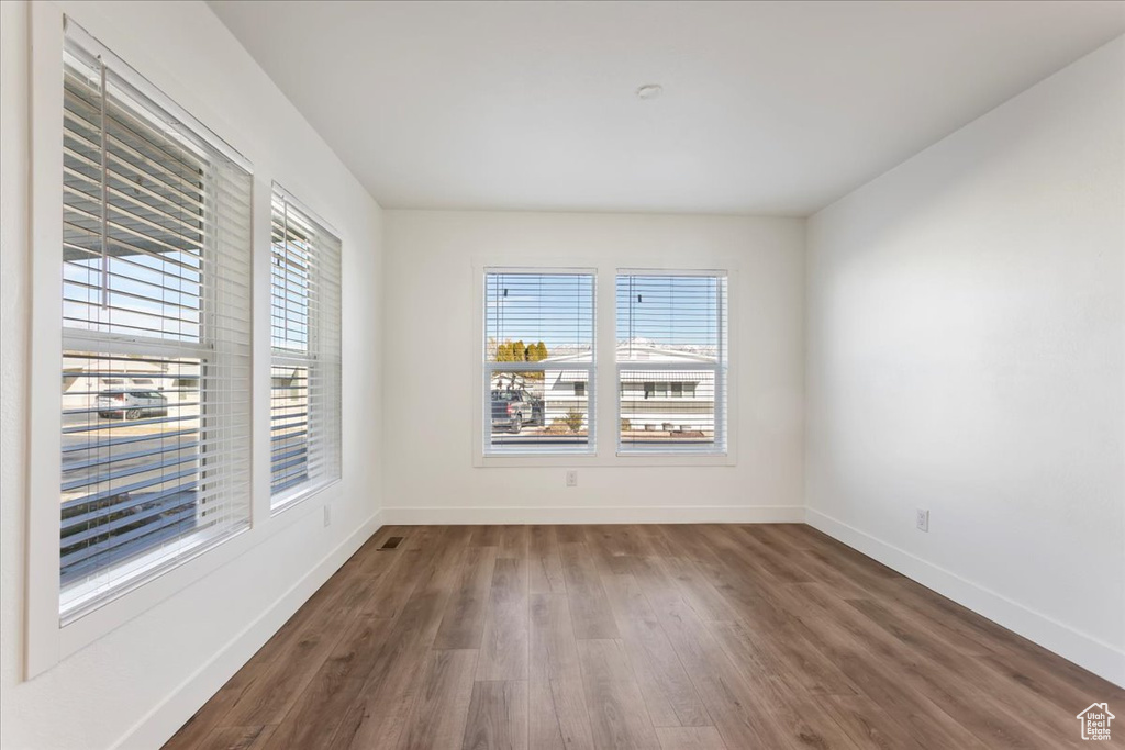 Spare room with baseboards and dark wood-style floors
