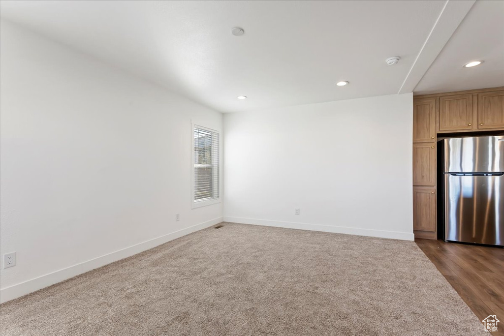 Empty room featuring recessed lighting, baseboards, and dark wood finished floors