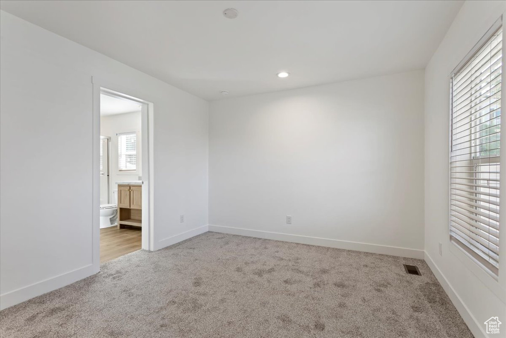 Carpeted empty room featuring baseboards, recessed lighting, and visible vents