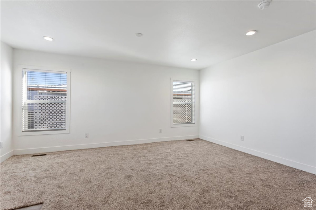 Spare room with baseboards, recessed lighting, and carpet