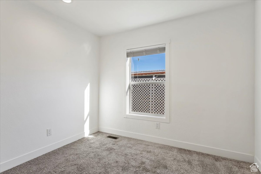 Spare room featuring baseboards, carpet flooring, and visible vents