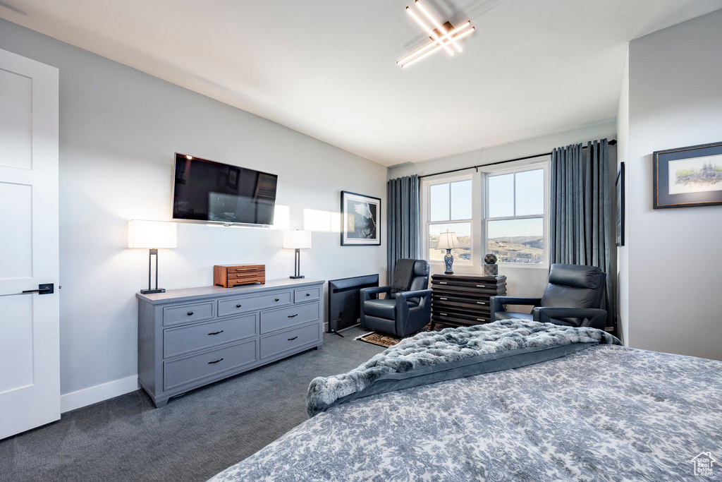 Bedroom with baseboards and dark colored carpet