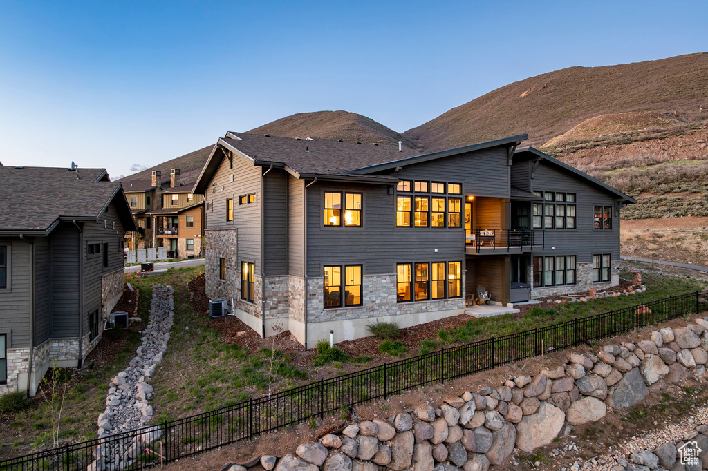 Back of house featuring a fenced backyard, a mountain view, and central air condition unit