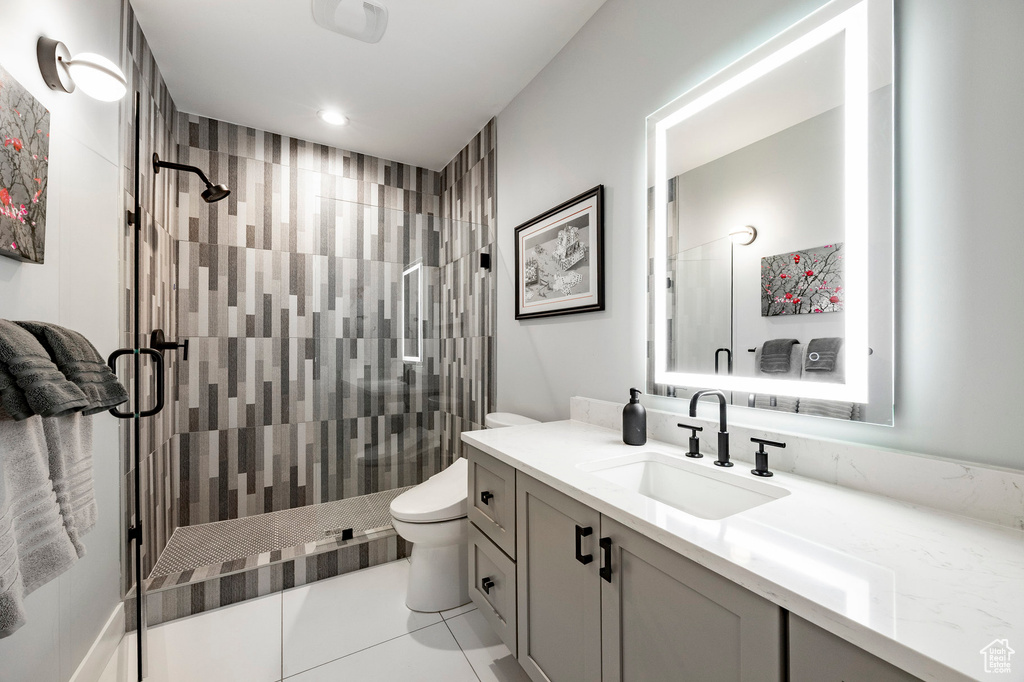 Full bath with vanity, toilet, tile patterned flooring, and a stall shower