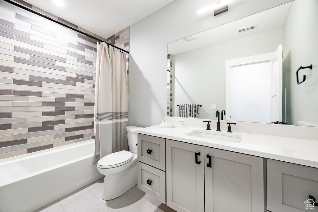 Bathroom featuring shower / bath combo, vanity, toilet, tile patterned floors, and visible vents