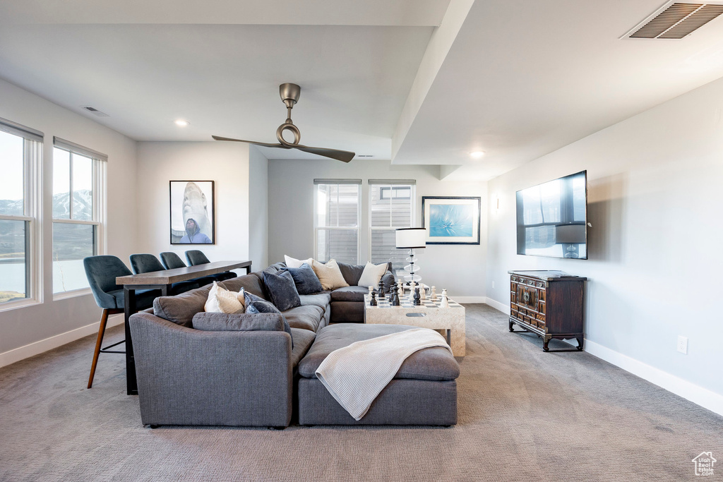 Living area with baseboards, a ceiling fan, carpet floors, and visible vents